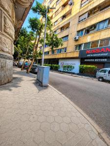 an empty street in front of a tall building at Havana ViP in Cairo