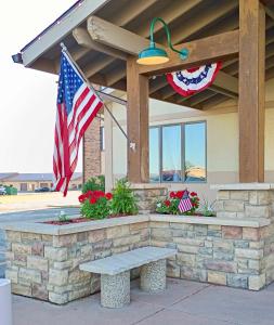 a bench in front of a building with an american flag at FairBridge Inn & Suites Spearfish in Spearfish