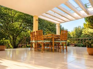a table and chairs on a porch with a pergola at Villa Serena in Mytikas