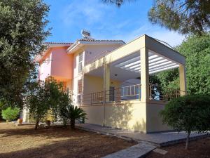 a house with a large balcony in a yard at Villa Serena in Mytikas