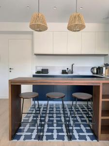 a kitchen with two bar stools and a counter top at Leiria Design Suites in Leiria