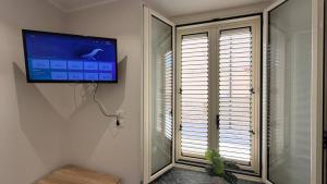 a flat screen tv hanging on a wall next to a window at RaJan Home Blue in Palizzi Marina