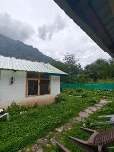a house with a roof and chairs in front of it at Pulga Inn in Kalgha