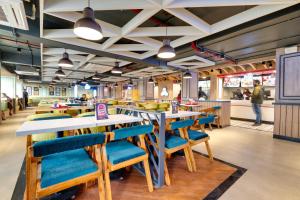 a restaurant with wooden tables and blue chairs at Hotel 11 Boulevard - Dal Lake View in Srinagar