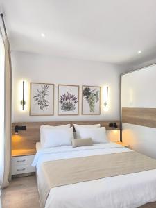 a bedroom with a large white bed with four pictures on the wall at Kostadinov Residence in Demir Kapija