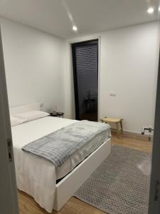 a white bedroom with a large bed and a window at MiraReal Guest House in Macieira da Lixa +23 photos