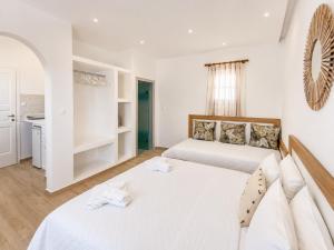 two beds in a room with white walls at Cyclades Blue in Ornos +37 photos