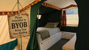 a bedroom with a bed in a tent with a sign at Ready Pitched Tent stay Bring your own bedding in Trefnant