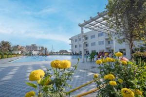 a swimming pool with yellow flowers in front of a building at ROYAL GITANJALI RESORTS & SPA in Mandarmoni