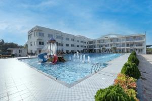 a swimming pool with a water slide in front of a building at ROYAL GITANJALI RESORTS & SPA in Mandarmoni