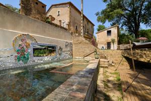 a swimming pool with a mural on the side of a building at Mas Ferrer Petit by 123ole in Sant Andreu del Terri +19 photos