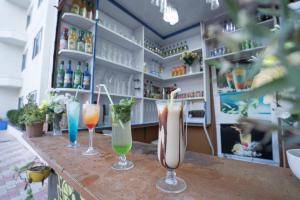 a bar with three drinks on a counter at ROYAL GITANJALI RESORTS & SPA in Mandarmoni