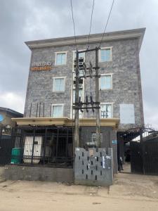 a building with a sign on the side of it at Hymax Grace hotel in Bolorunpelu