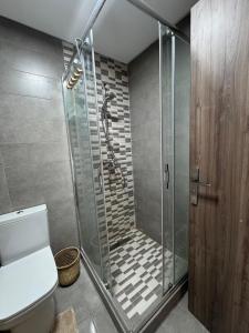 a bathroom with a shower with a toilet and a glass door at Smir Park apartamento in Marina Smir