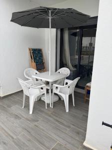 a white table with two chairs and an umbrella at Smir Park apartamento in Marina Smir +2 photos