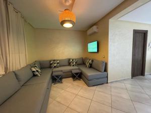 a living room with a couch and a tv at Smir Park apartamento in Marina Smir