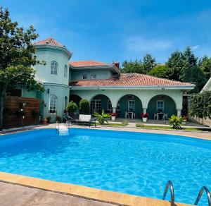 a large swimming pool in front of a house at SUNNY HOUSE APARTMENTS WITH an OUTDOOR POOL AND FREE PARKING in Skopje
