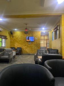 a waiting room with couches and a tv on a wall at Hymax Grace hotel in Bolorunpelu