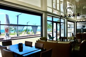 a restaurant with tables and chairs and a large window at Hotel Zich in Kobuleti