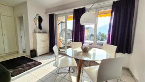 a dining room with a white table and white chairs at Wohnung nr 103 in Muralto