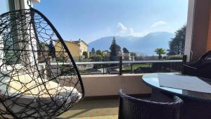 a basket chair sitting on a balcony with a view at Wohnung nr 103 in Muralto
