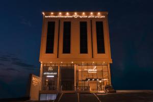 a tall building with lights on it at night at شقق وسن الفندقية in Abha