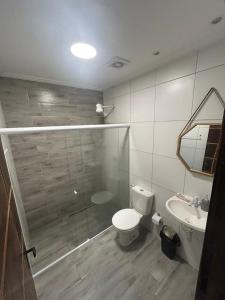 a bathroom with a shower and a toilet and a sink at Casa com piscima e área goutmet in Camaçari