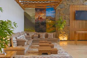 a living room with couches and a wall with a tv at شقق وسن الفندقية in Abha