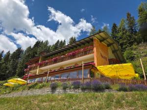 a building on a hill with flowers in front of it at Hotel Restaurant Raunig in Bad Kleinkirchheim
