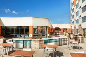 a patio with tables and chairs in front of a building at Four Points By Sheraton - Saginaw in Saginaw