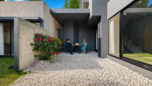 two people sitting at a table outside of a house at 陽月-Hizuki- in Nakijin