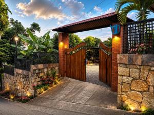 an entrance to a wooden gate with a stone wall at Finca cuatro orquídeas in La Mesa