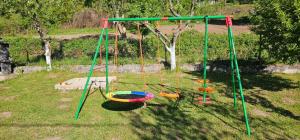 a playground with three swings in a yard at Wooden Fairytale in Bihać