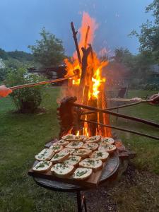 a bunch of food on a grill with a fire at Pensiunea Casa Godja in Văleni