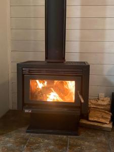 a stove with a fire inside of it at Tairua Tides - Relaxed Coastal Retreat in Tairua