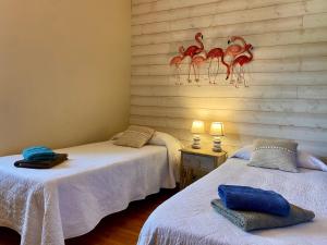 a room with two beds and a wall with a painting of animals at La Dorépontaise CHAMBRE D'HOTES in Pondaurat