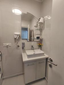 a white bathroom with a sink and a mirror at Apartman Sandra in Varaždin +23 photos