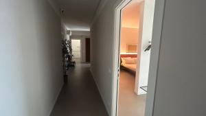 a hallway leading to a room with a bed and a mirror at Panda House - Padova Station in Padova