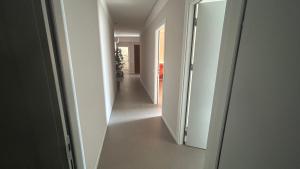 an empty hallway with white walls and a hallway with two doors at Panda House - Padova Station in Padova