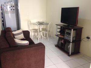 a living room with a couch and a flat screen tv at Casa de Aninha in Natal