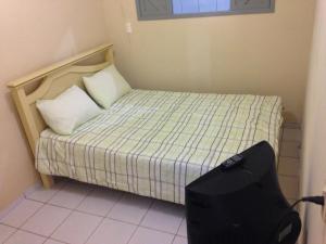 a small bedroom with a bed with a backpack on it at Casa de Aninha in Natal