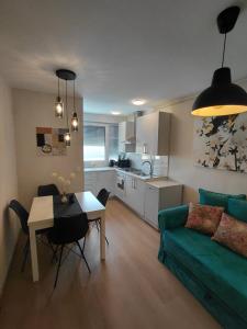 a living room with a green couch and a table at Apartman Sandra in Varaždin