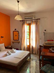a bedroom with a bed and a desk and a window at Studios Julia in Petra