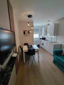 a living room with a dining room table and a kitchen at Apartman Sandra in Varaždin