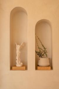 two shelves with a statue and a vase with a plant at CAPO LEFKADA Villa 97 - Sea View - Two Private Pools in Tsoukalades +45 photos