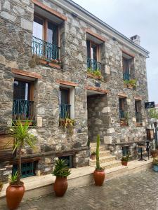 a stone building with potted plants in front of it at Ibri Hotel in Selçuk