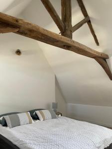 a bedroom with a large bed with wooden beams at Duplex de caractère in Coutances