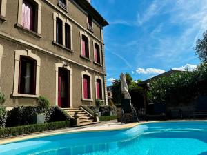 a house with a swimming pool in front of a building at La Villa de Mazamet in Mazamet