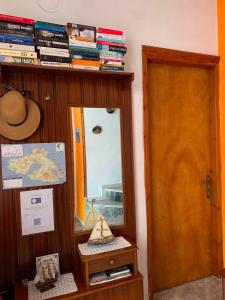 a room with a mirror and a shelf with books at Studios Julia in Petra