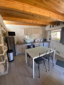 a kitchen with a table and chairs in a room at La maison D'Orée in Polignac
